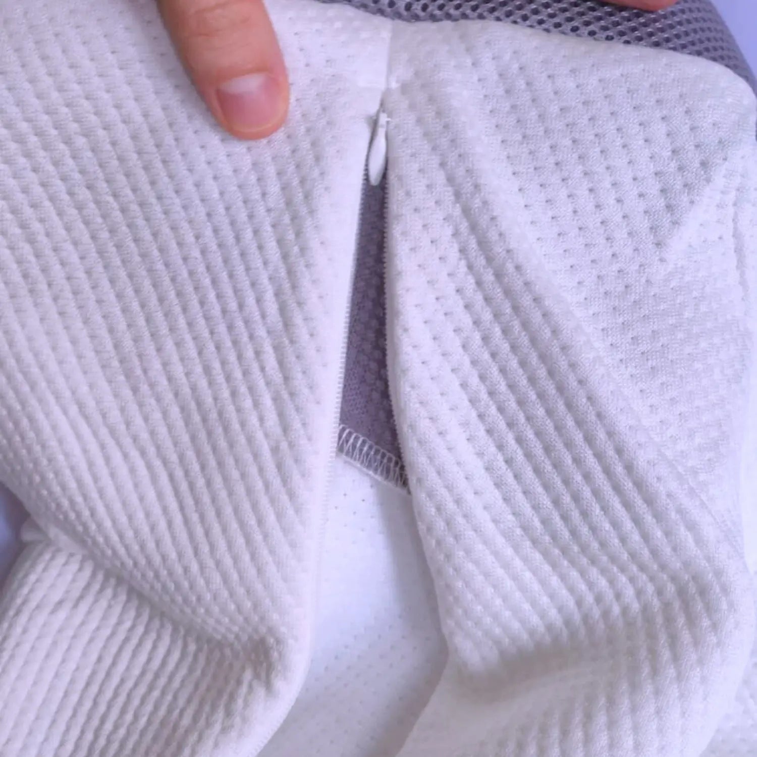 Close-up of textured white fabric with a hand holding it